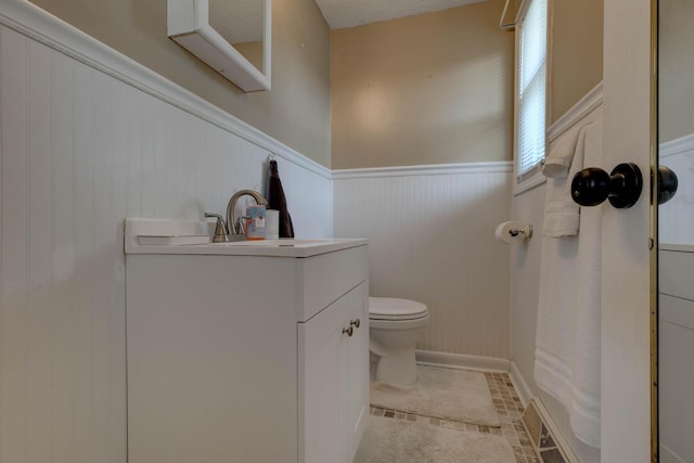 bathroom featuring tile patterned floors, vanity, and toilet