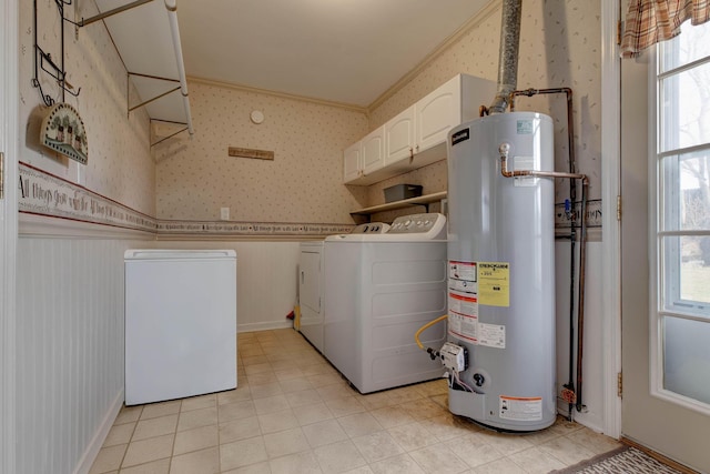 clothes washing area featuring separate washer and dryer, cabinets, crown molding, and water heater