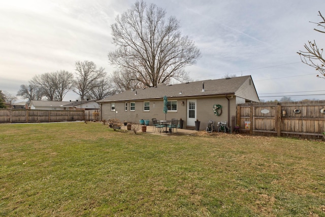 rear view of house with a yard and a patio