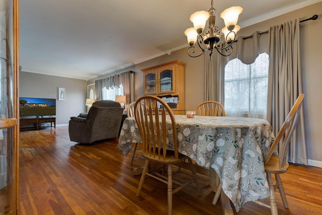 dining space featuring a notable chandelier, crown molding, and dark wood-type flooring