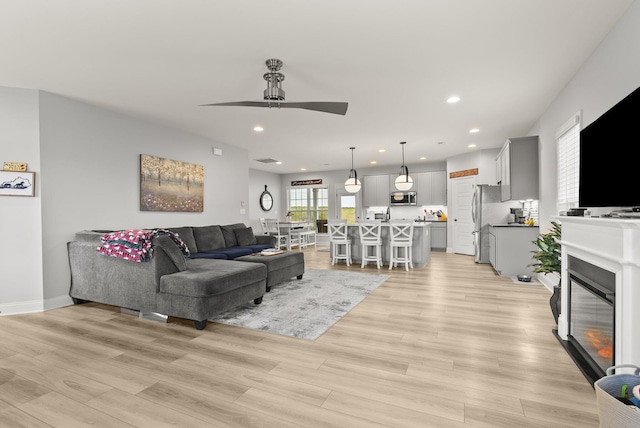 living room featuring ceiling fan and light hardwood / wood-style floors