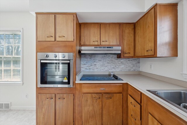 1952-1954 Fontaine Rd, Lexington, KY 40502 - kitchen with black electric cooktop, light countertops, tasteful backsplash, oven, and under cabinet range hood