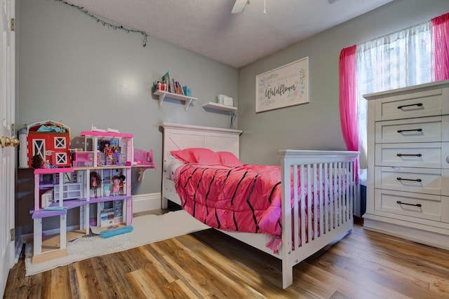 bedroom featuring ceiling fan, a textured ceiling, and light hardwood / wood-style flooring