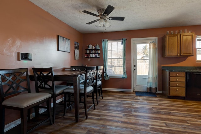 dining room featuring dark hardwood / wood-style flooring, ceiling fan, and a textured ceiling