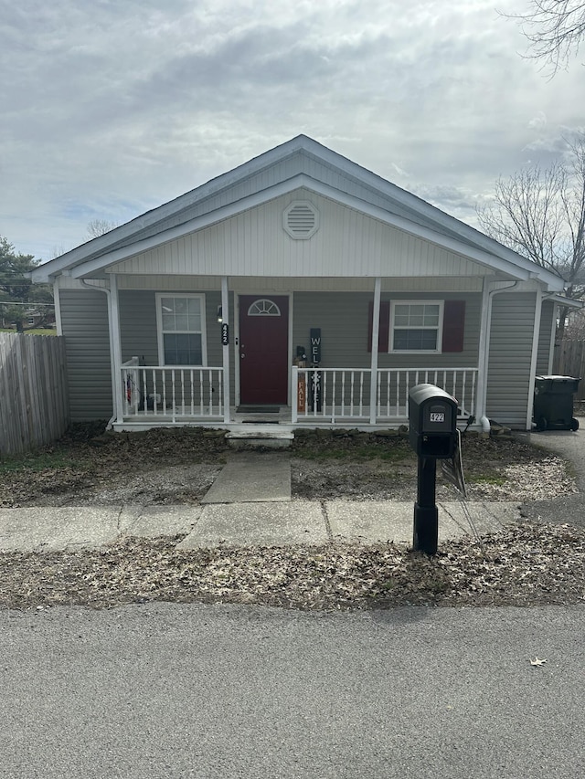 view of front of property with a porch and fence