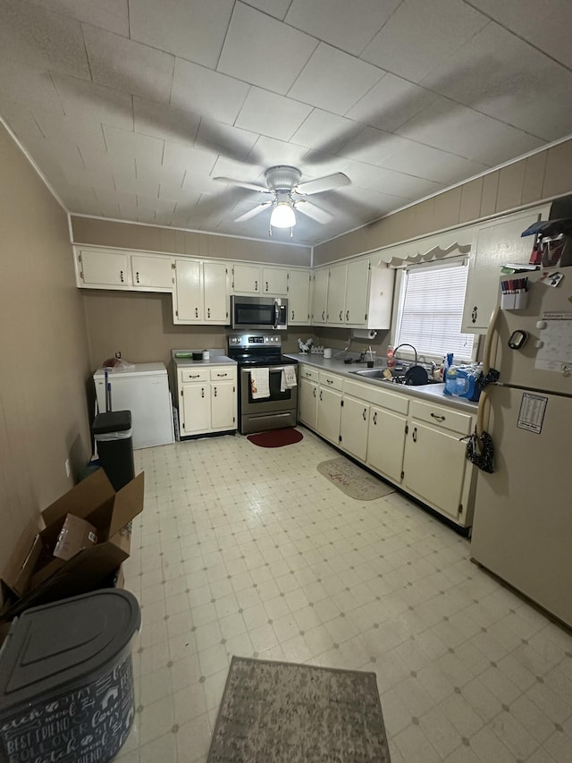 kitchen with sink, ceiling fan, appliances with stainless steel finishes, white cabinetry, and independent washer and dryer