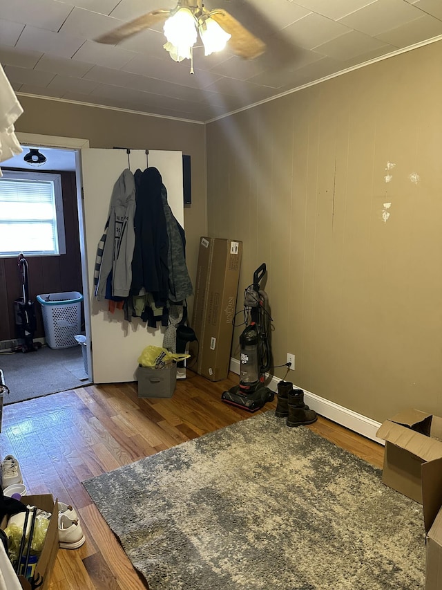 interior space with hardwood / wood-style flooring, ornamental molding, and ceiling fan