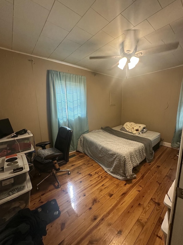 bedroom featuring a ceiling fan, hardwood / wood-style floors, and ornamental molding