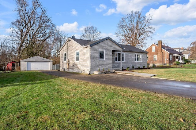 view of front of property with a garage, an outbuilding, and a front yard