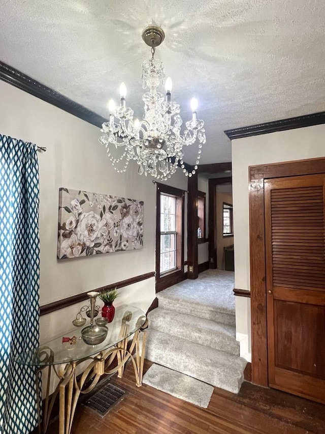 dining area with a chandelier, crown molding, a textured ceiling, and wood finished floors