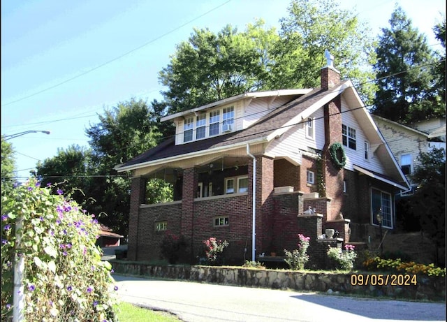 bungalow with brick siding and a chimney