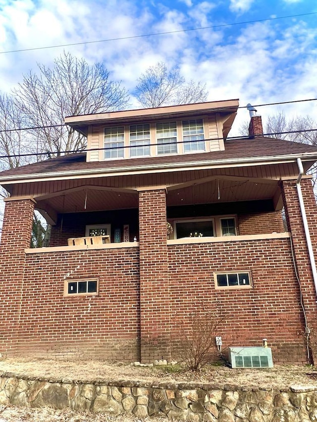 view of side of property featuring brick siding and a chimney