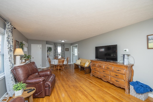 living room featuring light hardwood / wood-style flooring and a textured ceiling