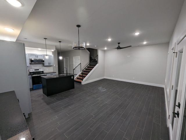 kitchen featuring decorative light fixtures, sink, dark hardwood / wood-style flooring, a kitchen island with sink, and stainless steel appliances