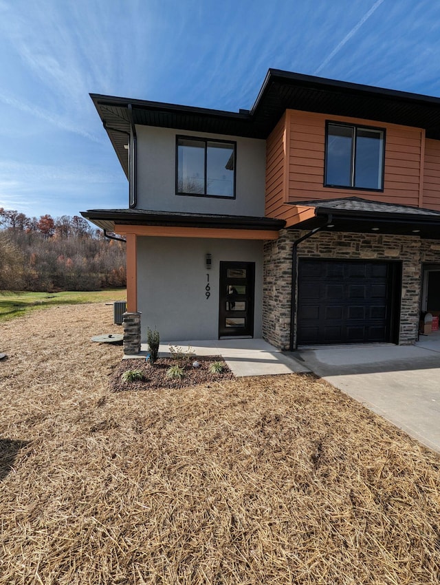 view of front facade featuring central AC unit and a garage