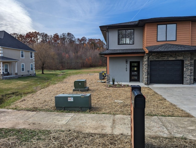 view of front facade featuring a garage and central AC