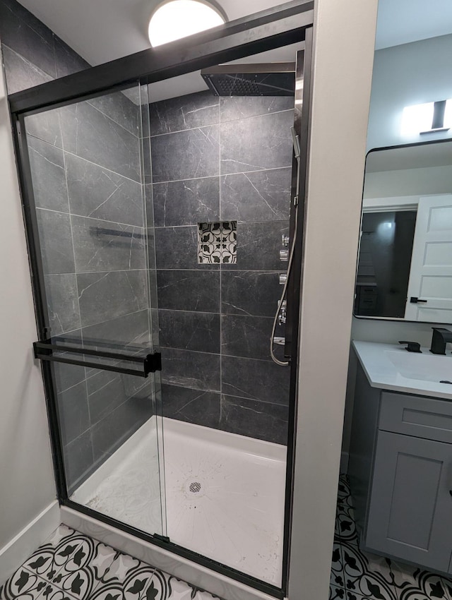 bathroom with tile patterned floors, a shower with shower door, and vanity