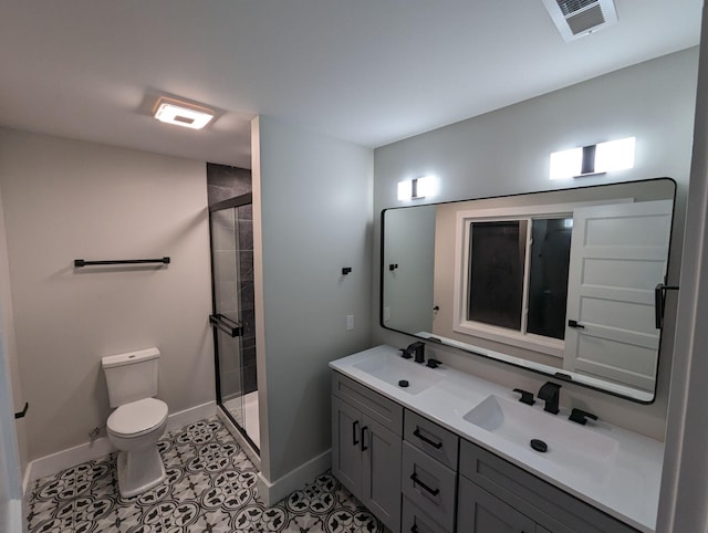 bathroom featuring tile patterned flooring, vanity, toilet, and walk in shower