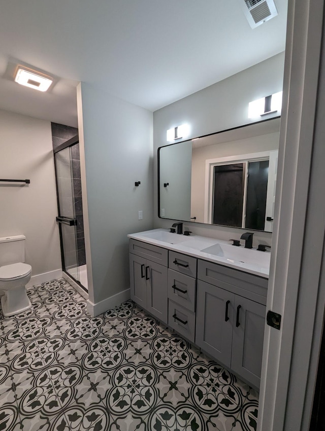 bathroom featuring an enclosed shower, vanity, tile patterned floors, and toilet