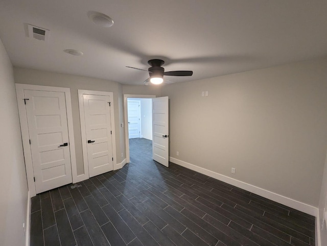 unfurnished bedroom featuring dark hardwood / wood-style floors and ceiling fan