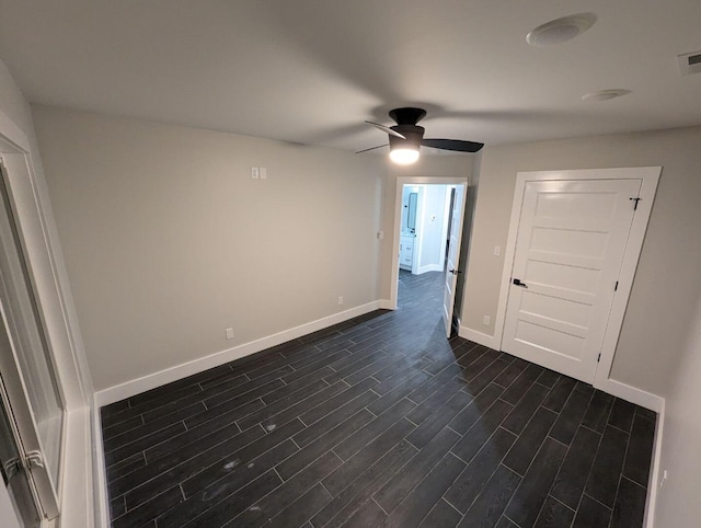 empty room featuring dark wood-type flooring and ceiling fan