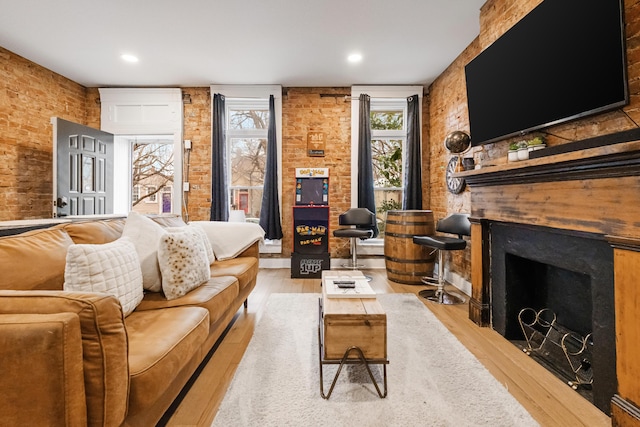 living room featuring brick wall and light wood-type flooring