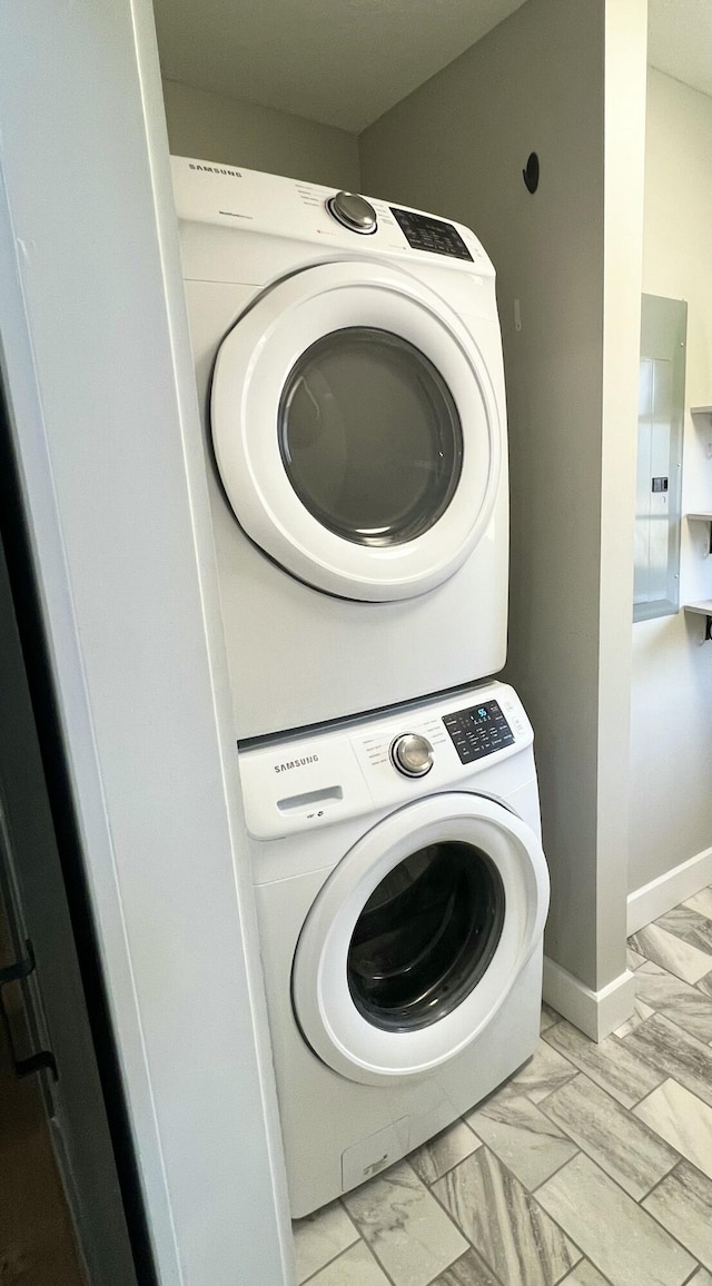 clothes washing area featuring stacked washer and clothes dryer