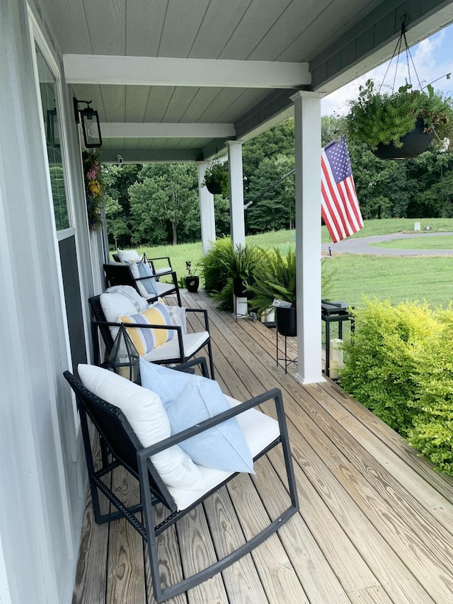 deck featuring covered porch and a lawn