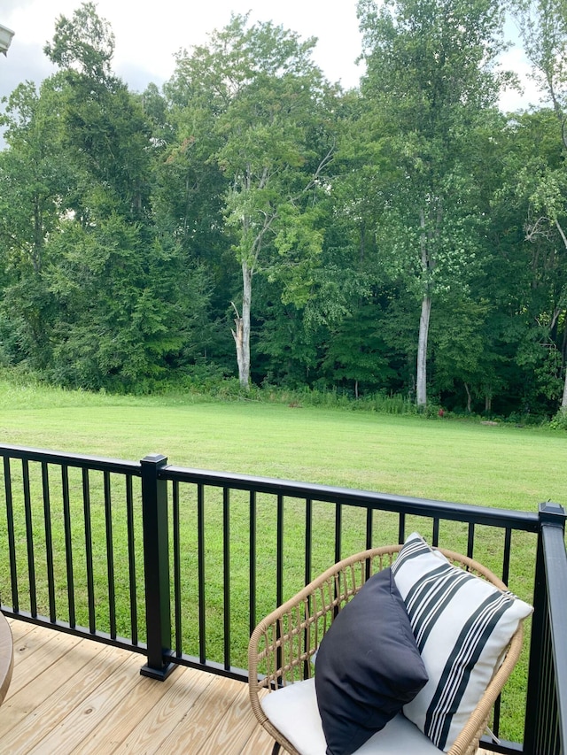 wooden terrace featuring a lawn