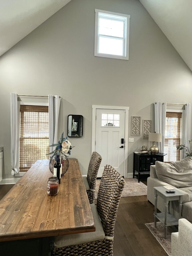 dining area with plenty of natural light, high vaulted ceiling, and dark hardwood / wood-style flooring