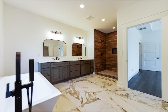 bathroom featuring vanity and independent shower and bath