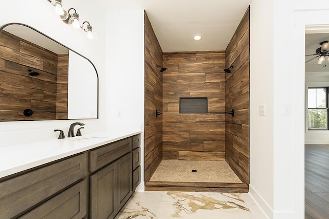 bathroom with vanity, ceiling fan, and tiled shower