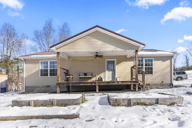 snow covered house featuring ceiling fan and a porch