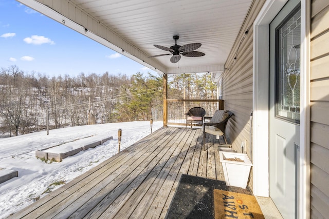 snow covered deck with ceiling fan and covered porch