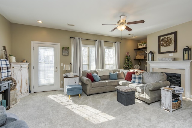 carpeted living area with ceiling fan, a fireplace, visible vents, and recessed lighting