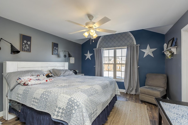 bedroom featuring a ceiling fan, lofted ceiling, baseboards, and wood finished floors