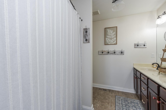 bathroom with visible vents, vanity, baseboards, and tile patterned floors