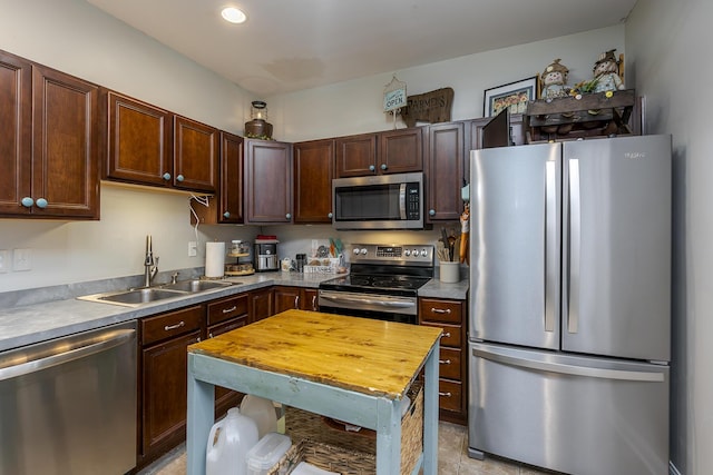 kitchen featuring dark brown cabinetry, recessed lighting, stainless steel appliances, butcher block countertops, and a sink