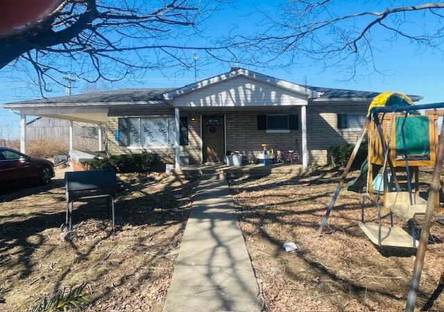 ranch-style house featuring a carport and a playground