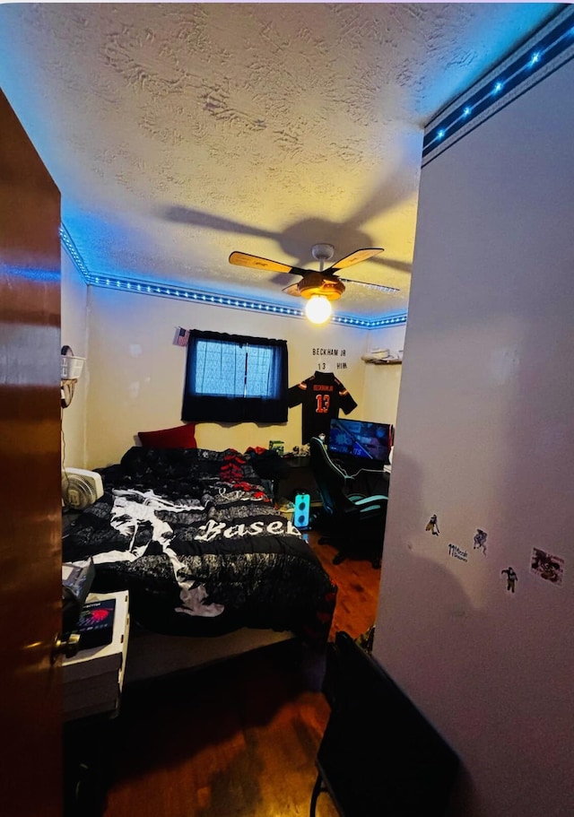 bedroom featuring hardwood / wood-style flooring, ceiling fan, and a textured ceiling