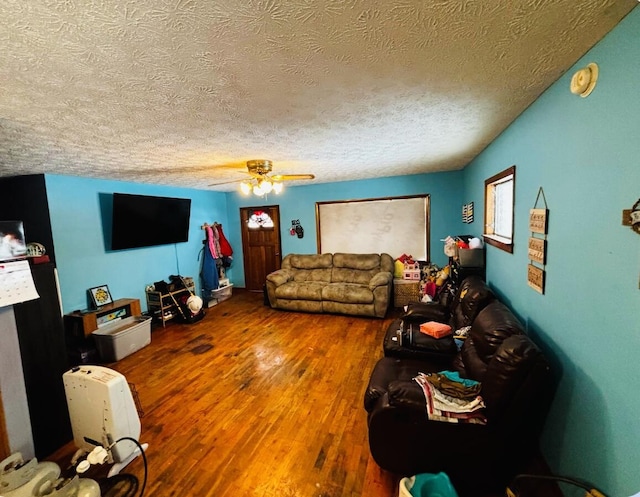 living room with ceiling fan, hardwood / wood-style floors, and a textured ceiling