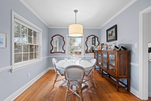 dining space featuring wood-type flooring and ornamental molding