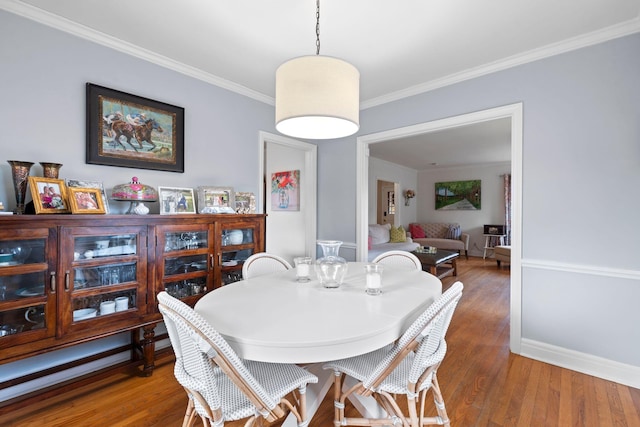 dining area with hardwood / wood-style flooring and ornamental molding