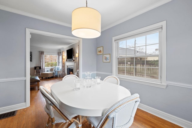 dining room with hardwood / wood-style floors and ornamental molding