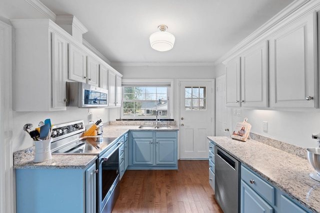 kitchen with blue cabinetry, sink, white cabinetry, crown molding, and stainless steel appliances