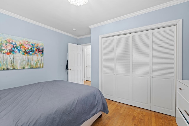 bedroom with light hardwood / wood-style flooring, ornamental molding, and a closet