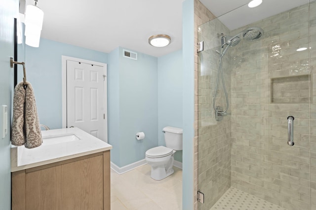 bathroom with a shower with door, vanity, tile patterned floors, and toilet