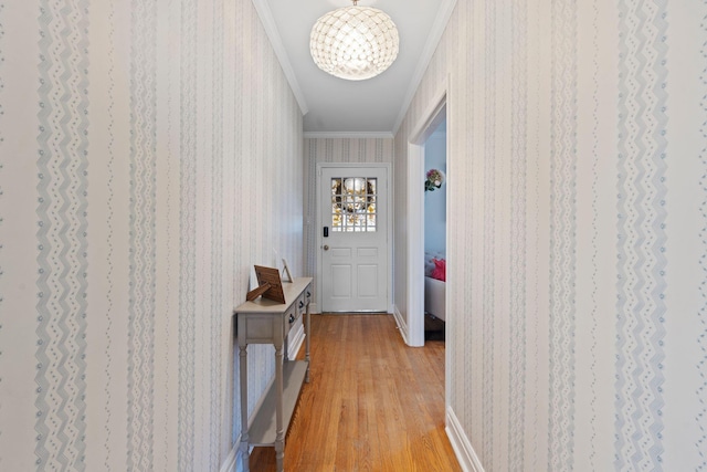 hallway featuring ornamental molding, light hardwood / wood-style floors, and a notable chandelier