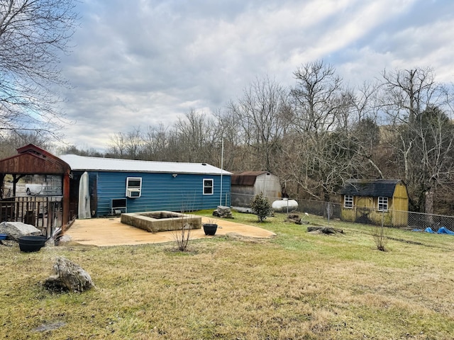 back of house featuring a patio, a lawn, and a shed