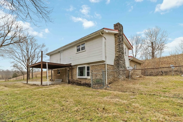 back of property featuring a patio area and a lawn